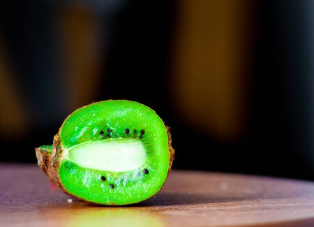 Close-up of kiwi cut in half, lying on the table, black backgroundの写真素材