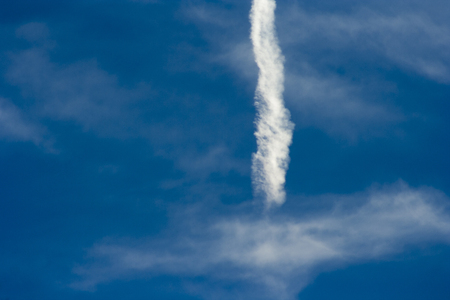 A beautiful blue sky with a dispersed streak of a flying airplane.