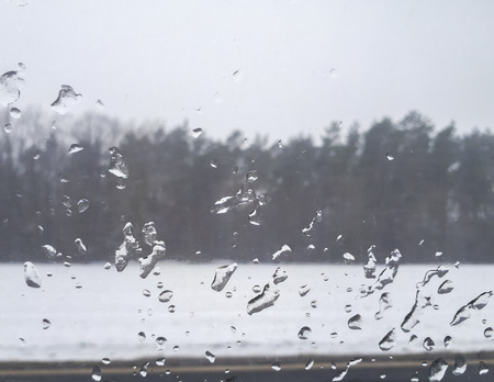 water drops on the glass in the car while drivingの写真素材