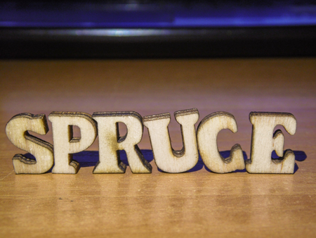 The word 'spruce' made of wooden letters. wood inscription on table