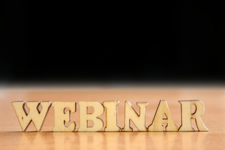 The word 'webinar' made of wooden letters. wood inscription on table and dark black backgroundの写真素材