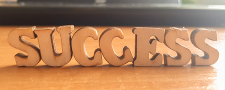The word 'success' made of wooden letters. wood inscription on table