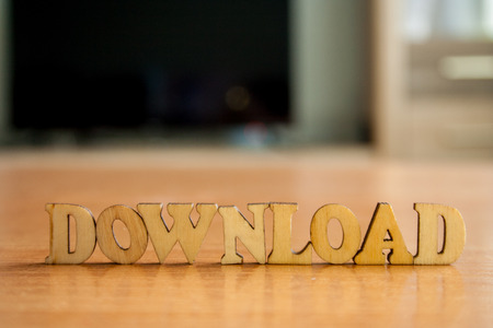 The word 'download' made of wooden letters. wood inscription on table