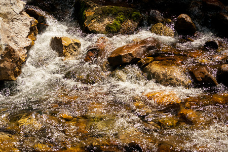 Close-up streams of water between mountain stones. Beautiful mountain river stream with fast flowing...
