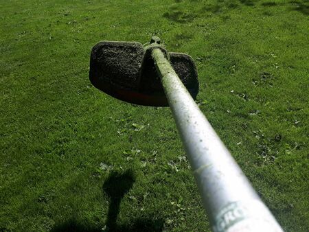 Head part of an old grass cutter machine on the grass backgroundの写真素材