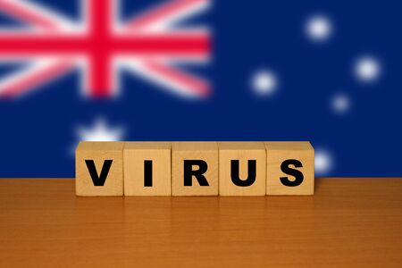 Virus message inscription on a wooden desk on cube blocks with a Australian flag background. Coronavirus concept.の写真素材
