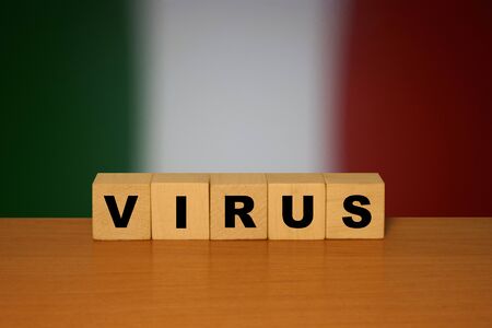 Virus message inscription on a wooden desk on cube blocks with a Italian flag background. Coronavirus concept.の写真素材