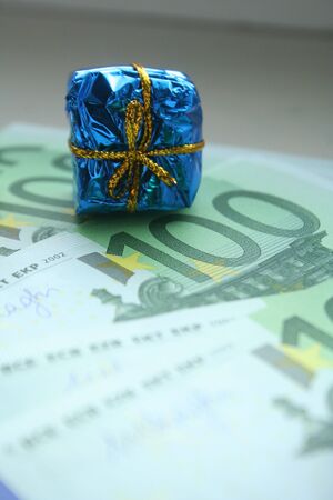 Mini gift on a euro banknote. The concept of free money, earning and benefits.の写真素材