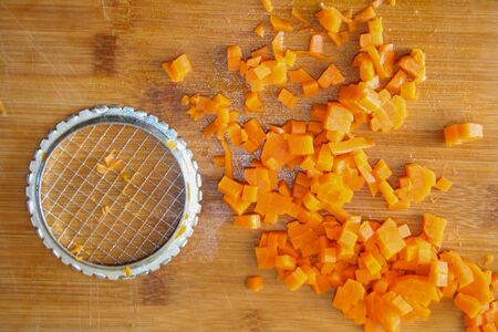 Carrot finely chopped. Preparing food, cutting vegetables, healthy food. slicing carrots into pieces in the kitchen. Food vegetable orange background.の写真素材