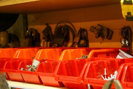 Red plastic box in the workshop for organization equipment and blolts background.
