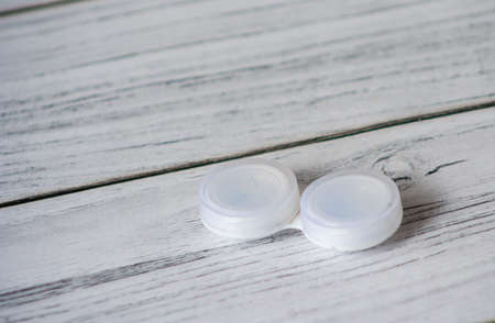 Lens container on wooden table. contact eye lense. Correction lens accessory background.