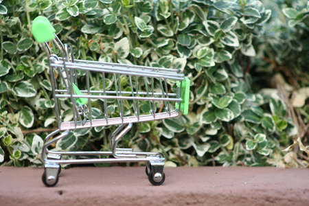 A mini shopping trolley on a table that shines on the sun symbolizing marketing and shopping as a concept of business.の写真素材