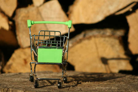 A mini shopping trolley on a table that shines on the sun symbolizing marketing and shopping as a concept of business.の写真素材
