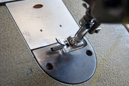 sewing machine foot and needle. Close up, macro. Empty space for text. Craft fabric industrial