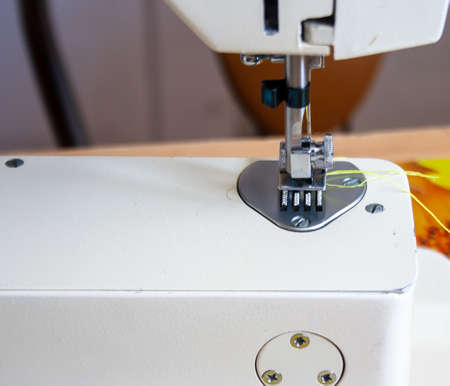 sewing machine foot and needle. Close up, macro. Empty space for text. Craft fabric industrial