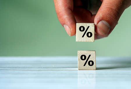 Hand turn wood cube block with percentage symbol icon. Interest rate, financial, ranking and...