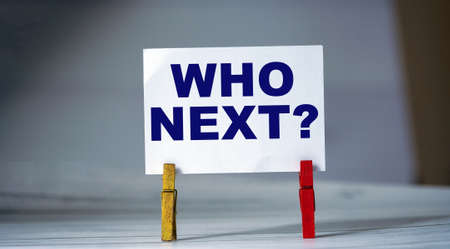 Reminder sticky note with clothes pin on table. Sticky note with inscription question WHO NEXT? President election in USA.の写真素材