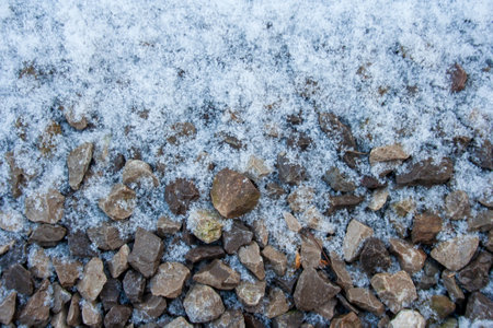 Small gravel road covered in snow texture. Winter pebble background. Dirty road. Fros morning. Snowy...