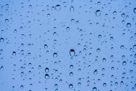 Drops of rain on the window or glass. Gray wet glass pattern texture. Abstract background