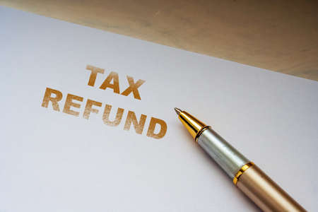 TAX REFUND message on office paper sheet with pen. Business concept. Return tax moneyの写真素材