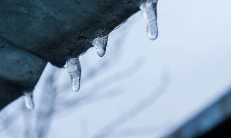 icicles on a roof. Winter concept. Icicles hang on a house roof.