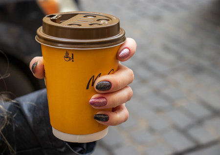 Cracow Poland, October 2, 2022: Cup of McDonald's coffee in a woman hand. Cup of McCafe coffee from McDonalds fast food restaurant.のeditorial素材