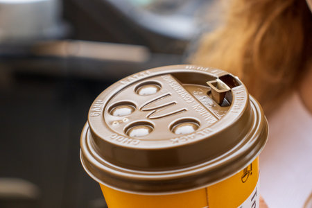 Cracow Poland, October 2, 2022: Cup of McDonald's coffee in a woman hand. Cup of McCafe coffee from McDonalds fast food restaurant.のeditorial素材