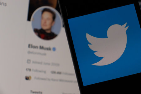 Warsaw Poland - February 22, 2023: Smartphone with Twitter logo on the screen. Elon Musk on backgroundのeditorial素材