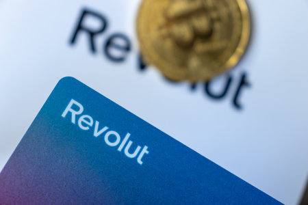 Warsaw Poland - February 18, 2023: Bitcoin and Revolut card logo. Crypto business. banking conceptのeditorial素材