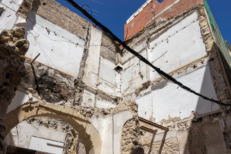 Abandoned building interior showing exposed walls and structural remnants under a clear blue sky; a striking example of urban decay and renovation potential.のeditorial素材