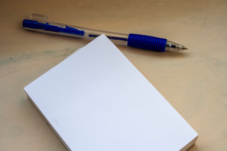 Blank notepad with a blue pen placed on a clean surface ideal for creative writing brainstorming or...