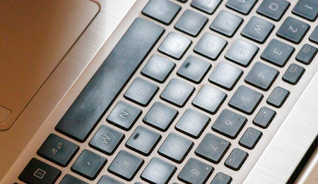 Close-up of a laptop keyboard showing the keys and their arrangement on a metallic surface. Ideal...