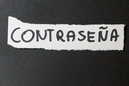 A close-up view of a torn piece of paper with the word CONTRASENA written in bold letters. The paper contrasts against a textured black background symbolizing security.の写真素材