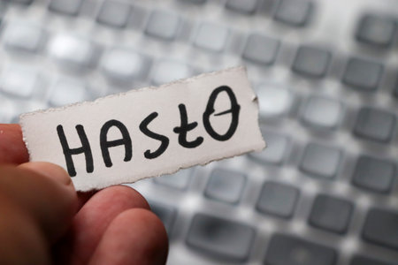 A hand holds a piece of paper with the word against a blurred computer keyboard background symbolizing communication and connection in the digital age.の写真素材