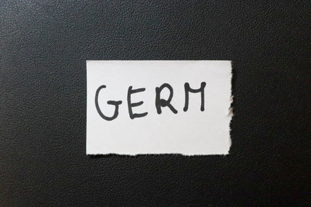 A piece of paper with the word GERM written in bold black letters on a textured black background....