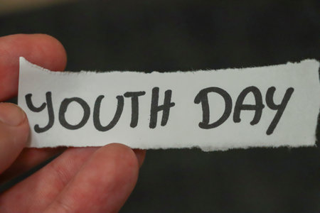 A hand holding a handwritten note that reads YOUTH DAY symbolizing celebrations or events dedicated to the younger generation promoting youth empowerment and engagement.の写真素材