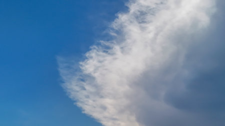 A beautiful cloud formation against a clear blue sky. The scene captures the dynamic interplay of light and shadow evoking a sense of tranquility and wonder.の写真素材
