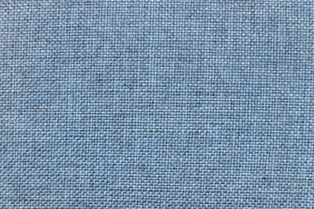 A close-up view of a textured blue fabric background showing a weave pattern. Ideal for designs and backgrounds offering a soft and modern touch to various projects.の写真素材