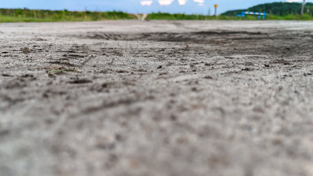 Close-up view of a dirt road with tire tracks showcasing a natural landscape. Ideal for illustrating...