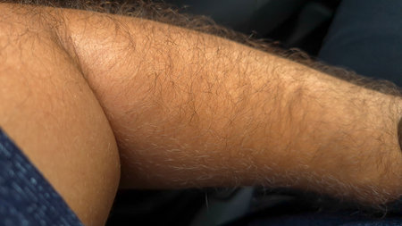Close-up of hairy arms resting in a casual setting capturing the texture and details of body hair...