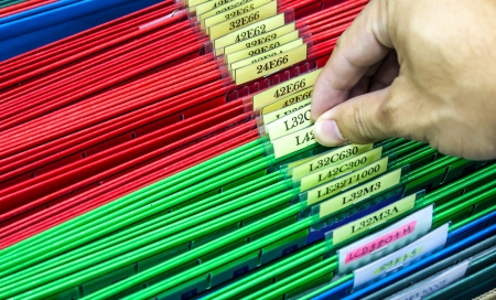 Abstract background image of colorful hanging file folders in drawer. Macro with with extremely shallow dof. Selective focus in front edges of files.の写真素材