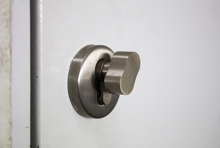 Detail of a metallic knob on white door horizontal