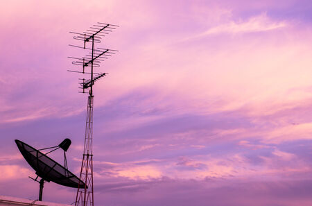 A black satellite dish on twilight sky backgroundの写真素材