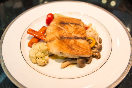 Snapper steak with sauce and boiled vegetables