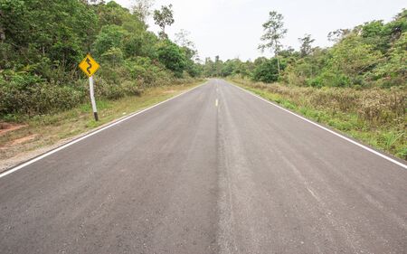 Curvy road sign to the mountain in rural areaの写真素材