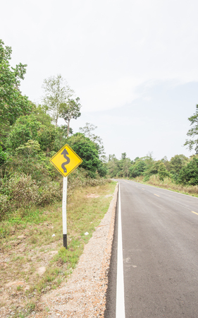 Curvy road sign to the mountain in rural areaの写真素材