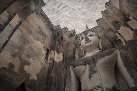 ancient seated buddha staue in the temple ruins of sukhothai in thailand.の写真素材
