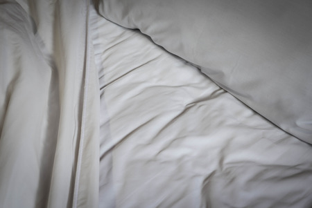 Messy white bed and the light shines, in the morningの写真素材