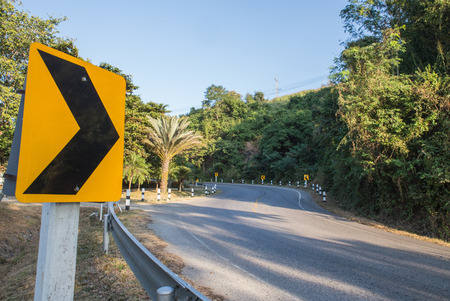 Asphalt road sharp curve along with tropical forest zigzag ahead.の写真素材