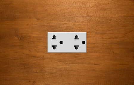 Double plug socket on the wall on wood  backgroundの写真素材